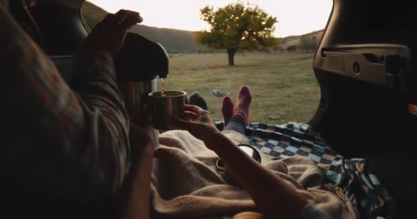 Araba kaç bagajında vakit relax bir yolculuktan sonra onlar hoş bir giyiyor çorap ve çay termosu günbatımında içme.. — Stok video