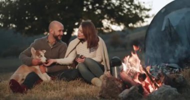 Husky köpekleri birbirlerine sarılma ile birlikte çok hoş vakit kamp ateşi doğanın ortasında genç çiftimiz piknik zamanı. 4k
