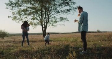 Mükemmel birlikte, iki küçük çocuğu kabarcıklar yaz günü güneşli yapma vakit doğa dört aile üyeleri. 4k