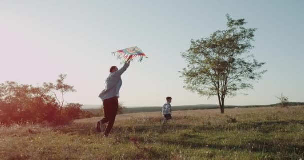 Papa à la nature avec son fils, jouant avec un kit. 4k — Video