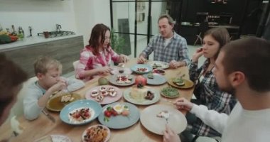 Aile birlikte bir akşam yemeği var onlar mutlu hizmet veren ve amazing mutfak tasarım renkli plaka lezzetli yemek yeme.