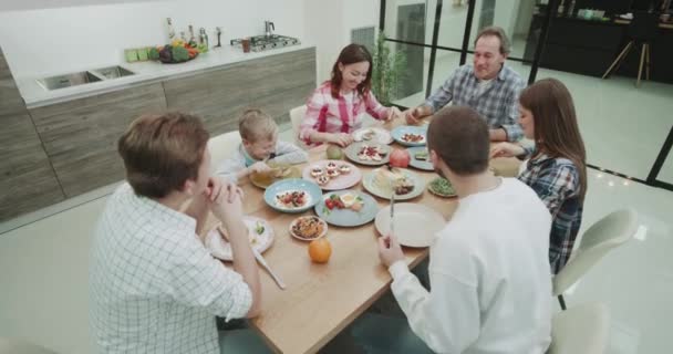 Grande famiglia hanno un pasto sano insieme troppo video prendendo in una cucina moderna. colpo om rosso epico . — Video Stock