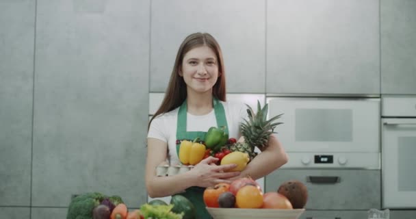 Ragazza dai capelli castani in possesso di frutta vibrante colorato e veg. 4k — Video Stock