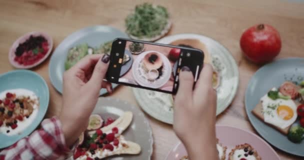 Någon tar en bild av olika färgglada näringsrika livsmedel på ett bord. — Stockvideo