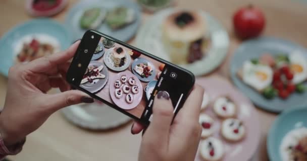 Uma menina cuidadosamente tirar fotos de alimentos para se certificar de que é claro . — Vídeo de Stock