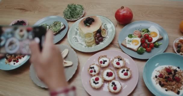 Хтось фотографує їжу, яка виглядає розмитою по телефону . — стокове відео