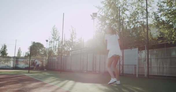 Equipado jugador de tenis mujer, en pista de tenis jugando profesional . — Vídeos de Stock