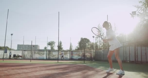 Wanita sportif berambut pirang muda bermain tenis profesional di luar pada hari yang cerah di lapangan tenis . — Stok Video