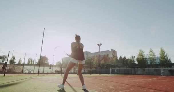 Profesional hembra equipada golpeando duro la pelota de tenis con raqueta de tenis . — Vídeo de stock