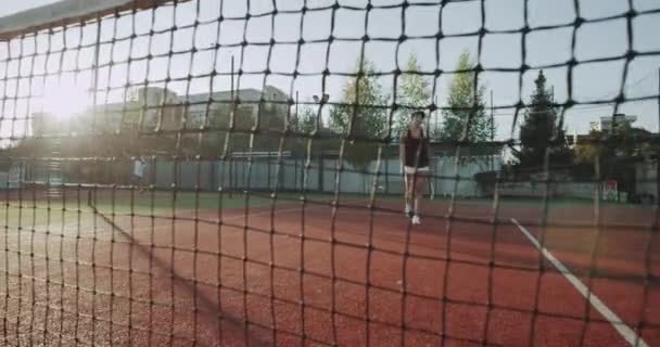 Dans la soirée de la journée, deux dames avant de commencer le match de tennis se tenant, et dire bonjour. 4k — Video