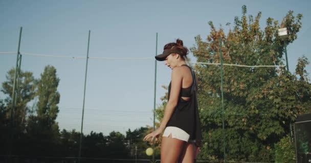 Mujer profesional con un cuerpo deportivo antes del partido de tenis venciendo a la pelota de tenis en el suelo. 4k — Vídeos de Stock