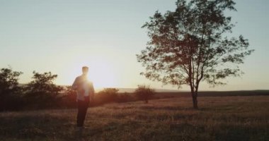 Güzel manzara, Doğa, tarlanın ortasında küçük bir raket ile oynayan genç karizmatik adam topu yendi..