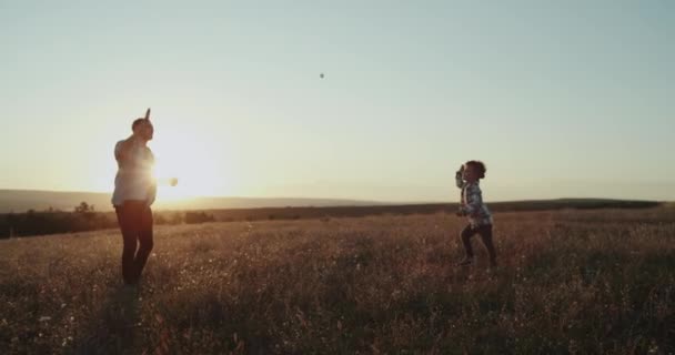 Niño de tres años jugando tenis divertido con su padre en la naturaleza, puesta de sol increíble, vista perfecta . — Vídeos de Stock