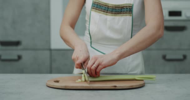 현대 부엌에서 여자는 카메라 앞에서 칼으로 큰 셀러리를 잘라. — 비디오