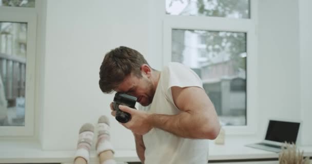 Moderna sovrum ung kille att göra några foto för hans flickvän i sängen, hon är väldigt karismatisk, poserar framför kameran. — Stockvideo