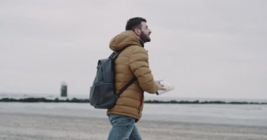 Turistik Sahil elini kolunu sallaya dönüyor. Mutlu erkek turizm seyahat ederken harita keşfetmek omuzlarında sırt çantası ile .