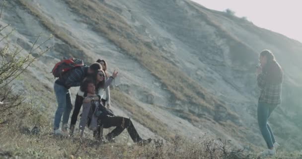 Prendre des photos pour des souvenirs grande compagnie de dames et de garçons s'amusent à faire des photos sur le voyage, debout au sommet de la montagne . — Video