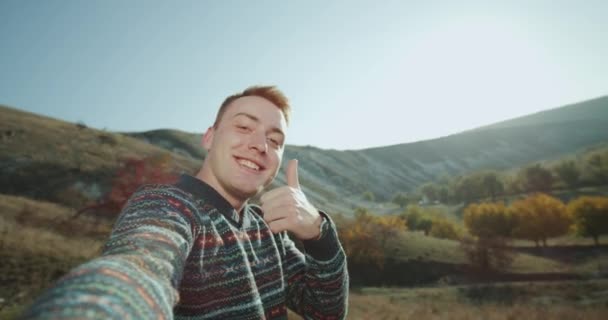 Grande sonriente pelirroja chico filmando su auto en la naturaleza tomando un selfie video . — Vídeos de Stock