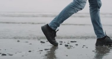 Video yakalama deniz kıyısı closeup ile yürüyen adam. 4 k. kırmızı epic vurdu. yavaş hareketleri