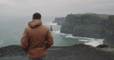 İnsan bir yer, muhteşem manzaralı, üst kısmında kayalıklarla Moher İrlanda mutlu kayalıklarla sahile yürüme. 4k