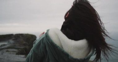 Şaşırtıcı Moher Cliffs uçuruma kıyı üzerinde duran kadın yerleştirin ve rüzgarlı bir günde meditasyon vaktim. 4k