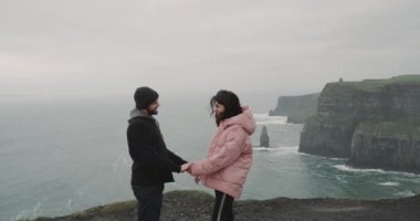 Güzel genç kız Moher Cliffs, adam olun onun Bayan bir öneriyi üstüne çift onlar birbirlerine sarılma çok mutlu ve sevinçli, uçuruma kıyı üzerinde duruyorlar vardır. 4 k Jacoby'ye kırmızı