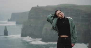 Güzel bayanın önünde uçuruma shore Moher ve karizmatik kamerayı düz seyir üzerinde kamera duran. yavaş hareketleri