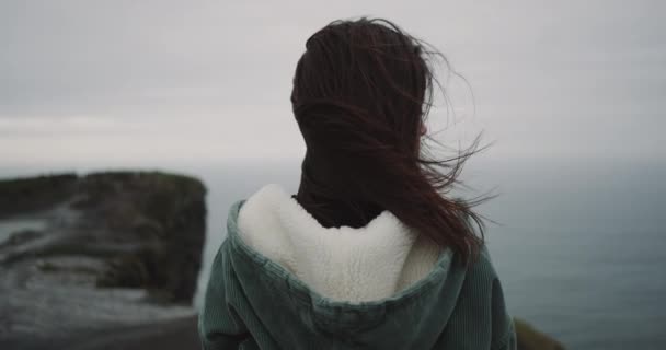 Verbazende jonge dame landschap bewonderen de Cliffs of Moher, close-up camera video nemen vanaf de achterkant van de dame. — Stockvideo