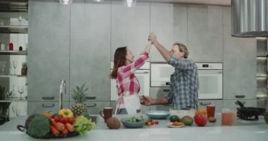Modern mutfakta Olgun çift romantik birlikte yemek pişirme sırasında vakit onlar dacing çok karizmatik.