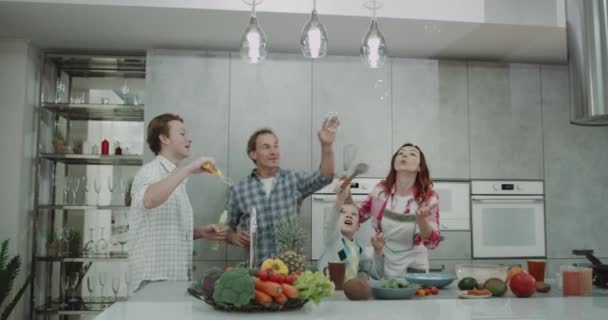 In the kitchen family spending a good time together playing with bubbles and dancing before making the healthy breakfast , modern kitchen with big kitchen island. — Stock Video