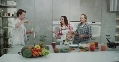 Karizmatik Aile Olgun Anne ve iki çocuğu bir aile birlikte kabarcıkları ile mutfakta kahvaltı yaparken oynama vaktim. 4k