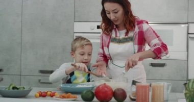 Pişirme süresi için anne ve oğlu güzel bir modern mutfakta yemek yaparken birlikte harcama zaman. 4k. Kırmızı epic vurdu
