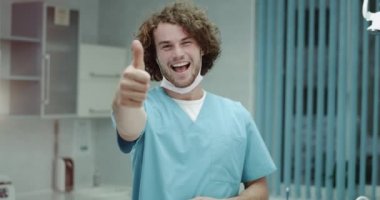 Mutlu o var, mutlu ruh hali ve tıbbi malzeme giyen büyük gülümseme gibi genç bir doktor veya cerrah mutlu bir hastanede kamera için büyük bir göstermek. yavaş hareketleri