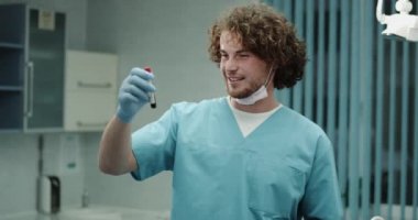 Kamerayı düz seyir ve onun hastanın kan küvet modern klinik odaya tutan karizmatik doktor erkek portre. 4k