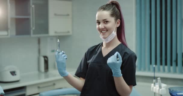 Feliz asistente de enfermeras dentistas sonrientes preparando una jeringa quirúrgica para una inyección mirando directamente a la cámara y sonriendo a lo grande . — Vídeo de stock