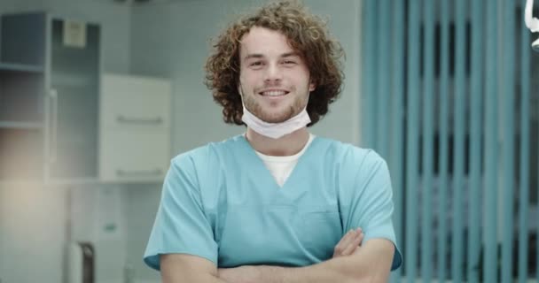 Nahaufnahme lächelnder charismatischer junger Arzt oder Chirurg, der direkt in die Kamera blickt, in einem Krankenhauszimmer, Arzt hat gute Laune und perfektes weißes Lächeln.
