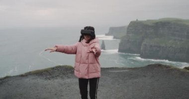 Cliffs genç bayan sanal gerçeklik gözlük ve mutlu çatıda, o doğanın ortasında bir teknoloji kavram için Vr kullanarak iyi eğlenceler.