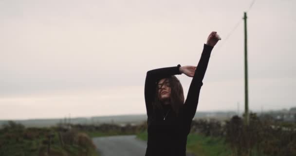 Jeune jolie dame au milieu de la route de campagne, caressant passionnément avec des yeux de placard devant la caméra . — Video