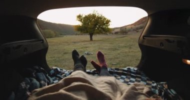 Doğa günbatımı için bekleyen arabanın bagajına ile hoş bir closeup video çift çorap. 4k