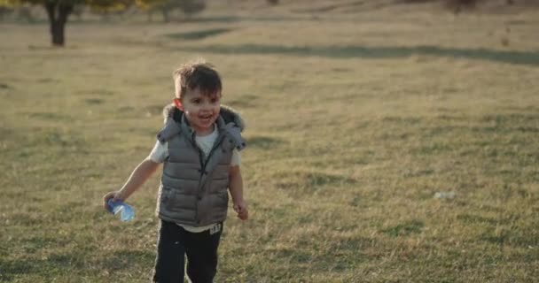 Divertido lindo niño corriendo en el medio archivado delante de la cámara — Vídeo de stock