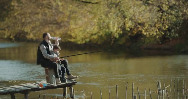 Padre che insegna a suo figlio a pescare al lago. Colpito da epica rossa. 4k — Video Stock