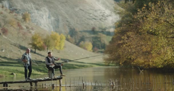 Dois amigos recreação juntos na natureza, eles pesca no lago . — Vídeo de Stock