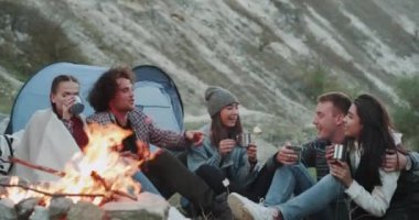 Çay saati için grup ile farklı ırklardan şenlik ateşi de akşam kamp ortasında, arkadaşıyla. 4k