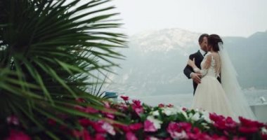 Dacing gelin ve damat ile arka plan, çok renkli çiçekler ve Yeşil Göl dağ ortasında muhteşem yerde yapraklar.