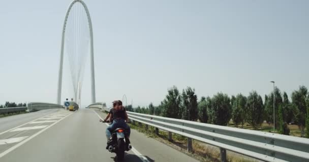 Op de motorfiets hebben jong stel een ritje op de snelweg in een zonnige perfecte dag. — Stockvideo