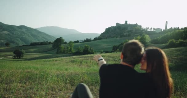 Pareja joven de buen aspecto disfrutando del tiempo juntos en medio de un paisaje increíble — Vídeos de Stock