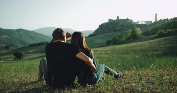 Inmitten einer atemberaubenden Aussicht auf die Landschaft verbringt ein Paar eine romantische Zeit miteinander, sie umarmen sich. — Stockvideo