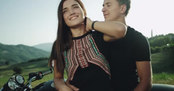 Detalhes de um jovem casal carismático passar um tempo encantador juntos no meio da paisagem incrível atrás de sua motocicleta — Vídeo de Stock