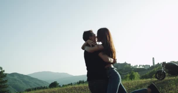 Casal jovem passar tempo romântico juntos em paisagem incrível, ao lado de sua motocicleta. 4k — Vídeo de Stock