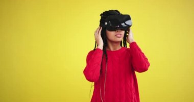 Uzun dreadlocks Afrika etnik çok etkilendim ilk kez sanal gerçeklik gözlük sarı bir arka plan ile bir stüdyoda kullanarak bir kadın, o karizmatik önünde oynarken çok mutlu